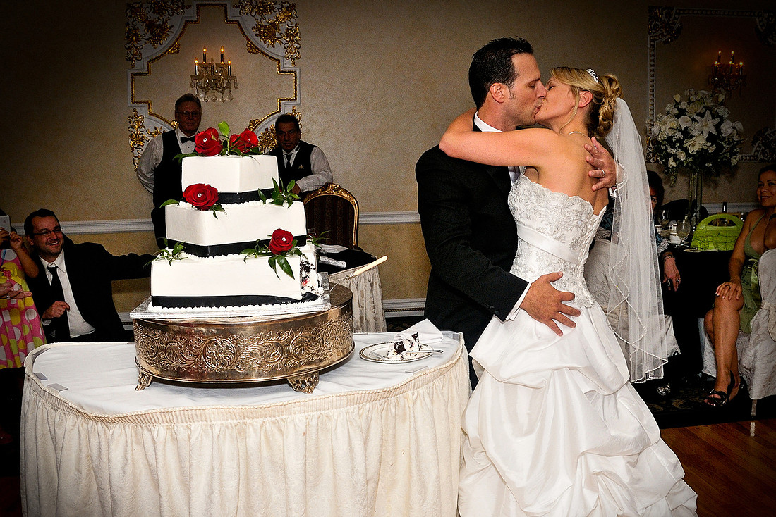 bride and groom kissing by cake by NJ Wedding Photographer