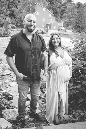 Maternity portrait near a waterfall, showing a profile view.