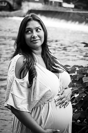 Black and white portrait of a smiling pregnant female.