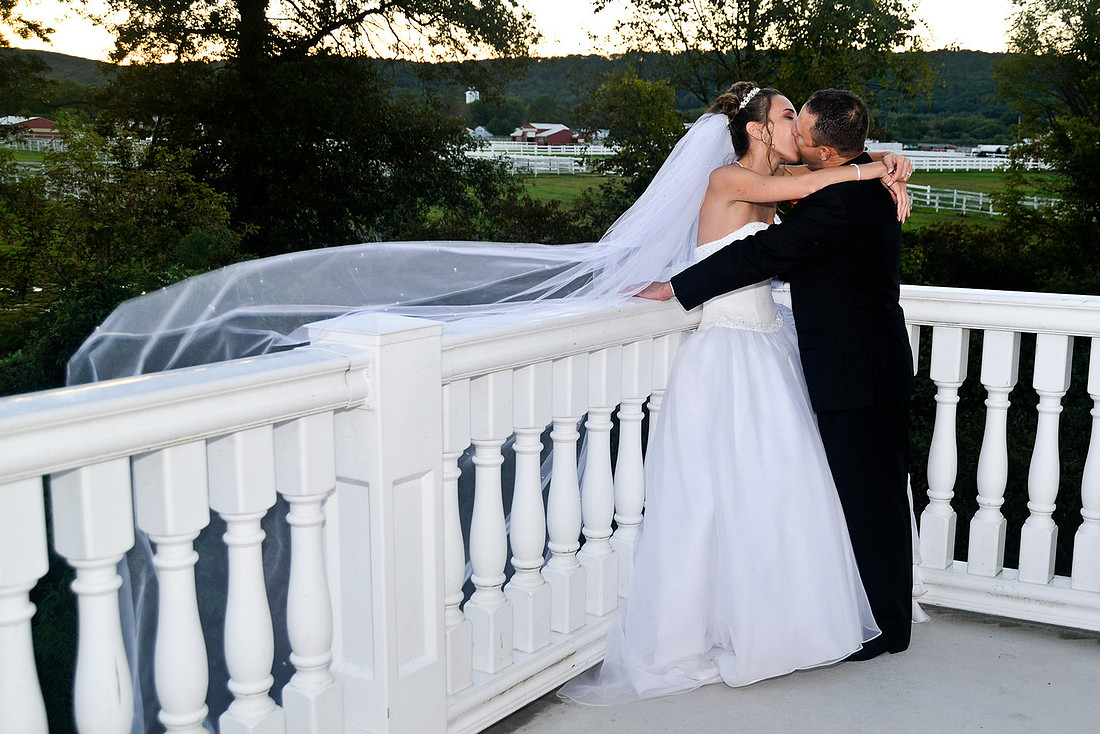 bride and groom kissing on balcony by NJ Wedding Photographer