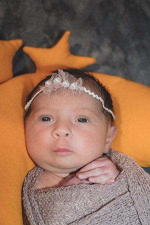 Portrait of a newborn lying down with eyes open, captured at the Clinton studio.