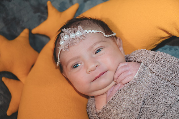 Another serene portrait of a newborn lying down with eyes open at the Clinton studio.