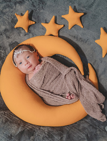 Another newborn portrait with eyes open in a basket, captured at the Clinton studio.