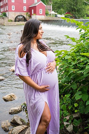 Maternity session by a waterfall with a smiling male and female.