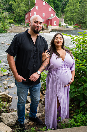 Wedding maternity portrait near a waterfall featuring a bride and groom.
