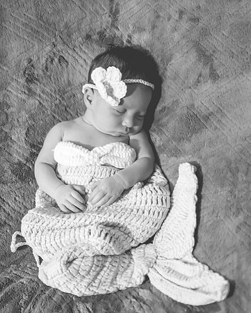 Black and white newborn portrait in a basket at Clinton studio with a smile.