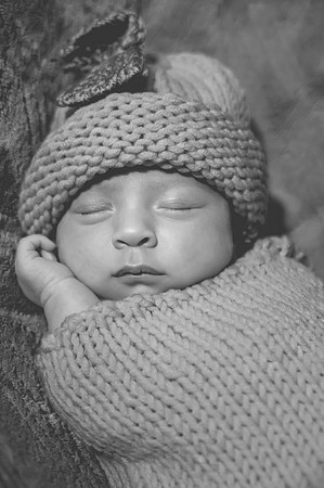 Newborn session at Clinton studio with colorful kneeling pose, featuring a smiling male child.