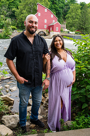Black and white maternity portrait of a smiling female in profile view.