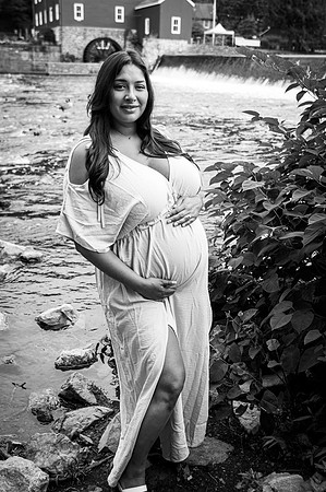 Black and white maternity portrait of a couple at a waterfall.