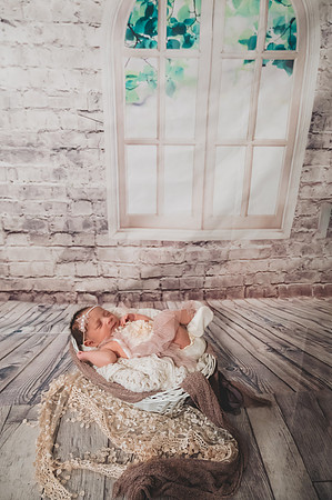 Colorful newborn session at Clinton studio featuring a kneeling male child.