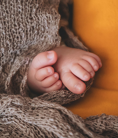Newborn sleeping in a basket, eyes closed, captured at the Clinton studio.
