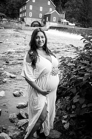 Bridal couple maternity portrait near a waterfall.