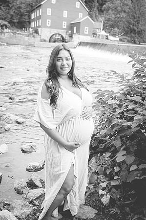 Maternity portrait near a river with complementary colors.
