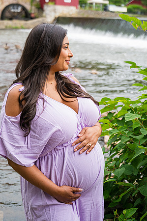 Maternity session at a waterfall with a smiling male and female.