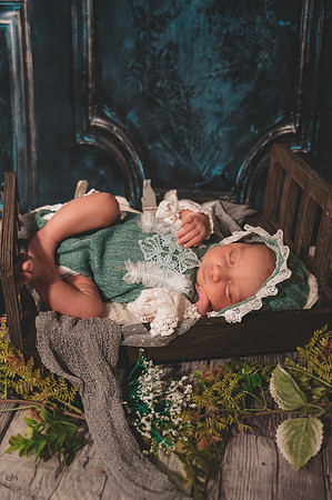 Colorful newborn portrait at Clinton studio featuring a kneeling male child.