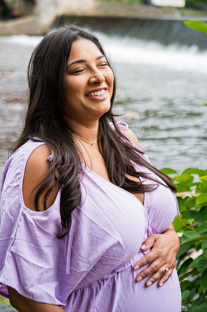 Black and white portrait of a smiling pregnant female.