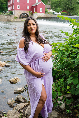 Newborn session at Clinton studio with colorful kneeling pose, featuring a smiling male child.