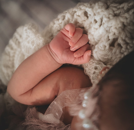 Colorful newborn portrait at Clinton studio featuring a kneeling pose.