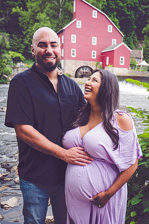 Maternity portrait of a smiling couple, showing a profile view.