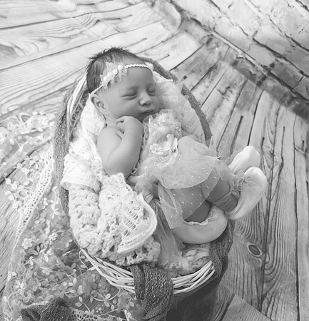 Portrait of a pregnant female with brown hair and eyes closed.