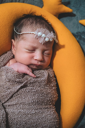 Newborn portrait featuring two faces, including a male child.