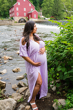 Maternity session by a waterfall with a smiling male and female.
